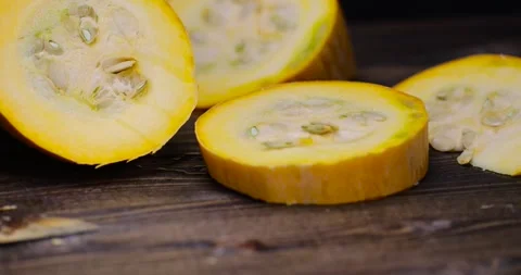 Slice yellow-orange ripe pumpkin or zucchini, slicing ripe zucchini on a black Stock Footage 313578482