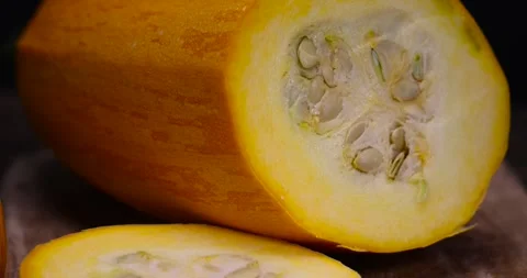 Slice yellow ripe pumpkin or zucchini, slicing ripe zucchini on a black cooking Stock Footage 313180853