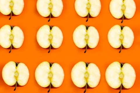 Sliced apple pattern on orange background, minimal concept Stock Photos