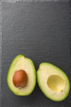 Sliced avocado on a stone background Stock Photos