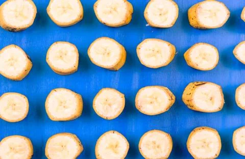 Sliced banana pattern on blue background horizontal Stock Photos