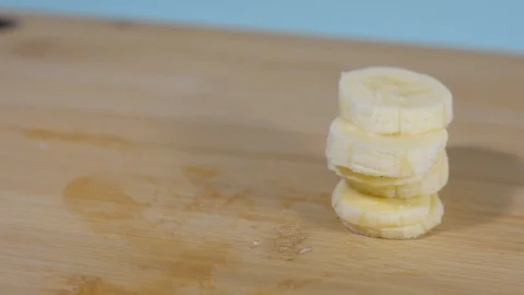 Sliced ​​banana slices on a table in the kitchen. Stock Footage 128917779
