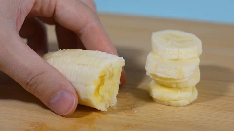 Sliced ​​banana slices on a table in the kitchen Stock Footage 128917780