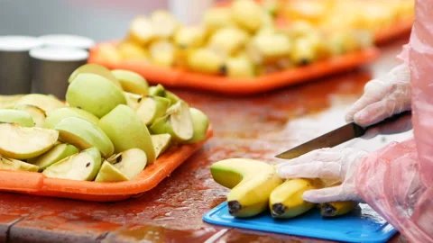 Sliced bananas and apples on the table for runners on refreshment point marathon Stock Footage 97529484