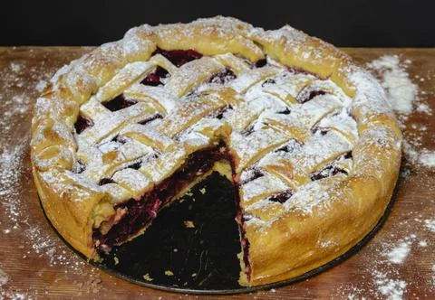 Sliced beautiful round cherry pie with pastry lattice and powdered sugar Stock Photos