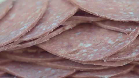 Sliced beef salami stacked in pile rotating slowly closeup view of processe.. Stock-Footage 332887694