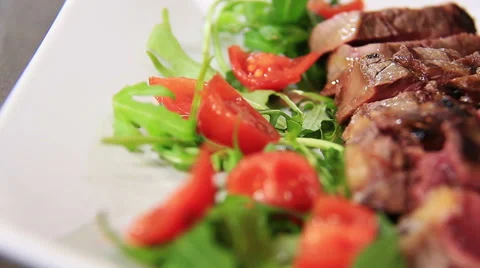 Sliced beef, sliced steak with arugula and cherry tomatoes: closeup footage Stock Footage 61356676