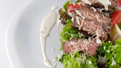 Sliced Beef steak or meat salad with parmesan cheese, tomatoes, eggs and sauce Stock Footage 81004207