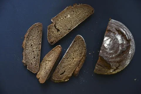 Sliced black bread on a black background. A loaf of black bread with slices o Foto stock