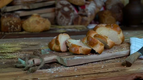 Sliced Braided bread on a table with wheat and a knife on the background of a va Stock Footage 109553900