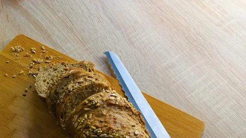 Sliced bread and bread knife on wood plate. Stock Photos