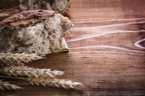 Sliced bread and ears of rye on vintage wooden board horizontal version food and 스톡 사진