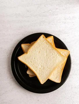 Sliced bread on black plate. Flat lay. Stock Photos