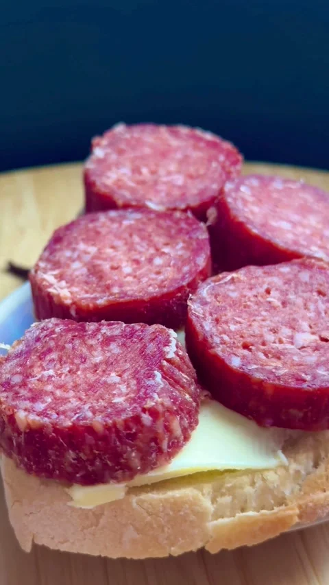 Sliced bread with butter and thick red salami rounds Stock Footage 331983396