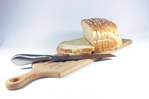 Sliced bread, cutting board and knife  isolated on white background Stock Photos