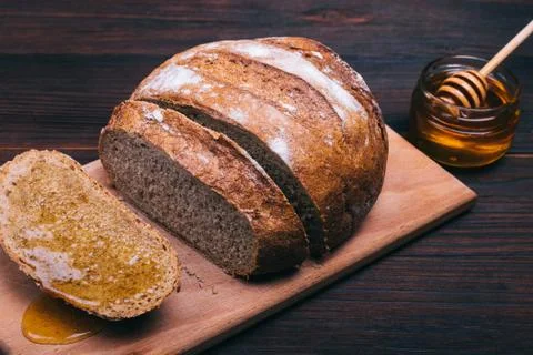 Sliced bread with honey on a brown table Stock Photos