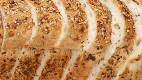 Sliced bread on the kitchen board. Bread with seeds, top view. Stock Footage 144925935