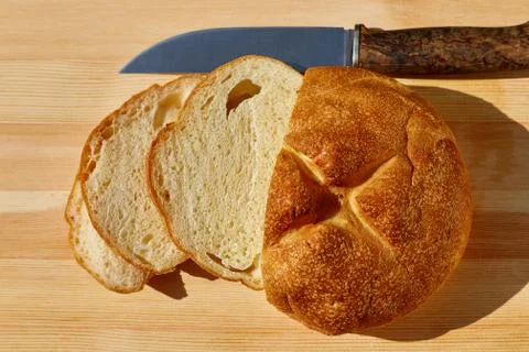 Sliced bread lying on the table and knife top view Stock Photos