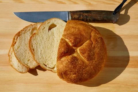 Sliced bread lying on the table and knife top view Stock Photos