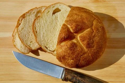Sliced bread lying on the table and knife top view Stock Photos