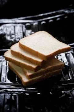 Sliced bread put on black background,blurry light around Stock Photos