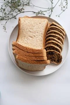 The sliced bread put in white dish,on white desk,blurry light around. Foto stock