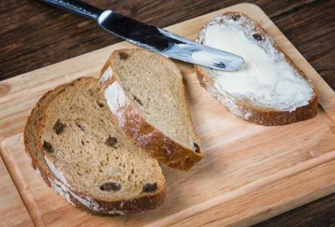 Sliced bread smeared with butter close-up on table Stock Photos