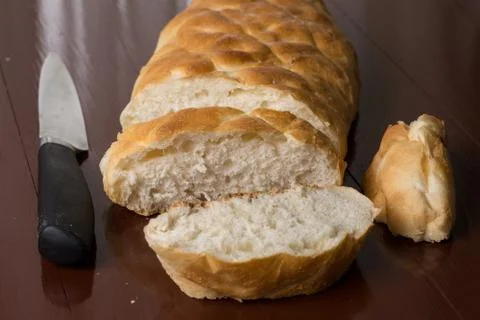 Sliced bread on the table with knife in the background Foto stock