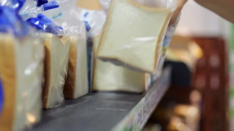 Sliced bread for toasts packed in individual plastic bags, woman pick one Stock Footage 221414586