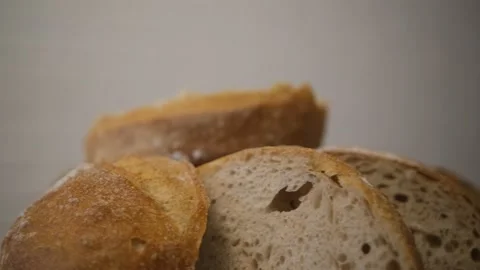 Sliced bread. Whirls of freshly baked bread in the bakery. Wooden table. Brown c Stock Footage 148603843
