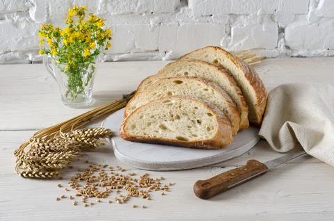 Sliced bread on white wooden table. Stock Photos