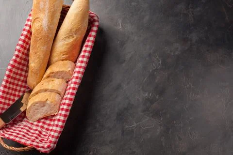 Sliced bread in a wicker basket over dark stone table. View from above with c Stock Photos