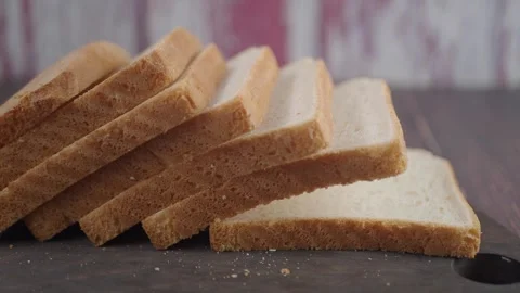 Sliced bread on a wooden board in kitchen setting Stock Footage 337752576