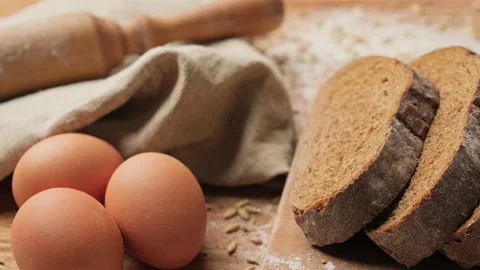 Sliced brown bread at cutting board. Camera sliding to the left. Organic food. Video stock 204038602