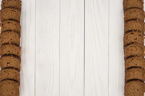 Sliced brown bread on an old white wooden table. Stock Photos