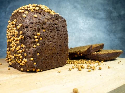 Sliced ??brown bread sprinkled with coriander. Borodino bread. Flour product. Stock Photos