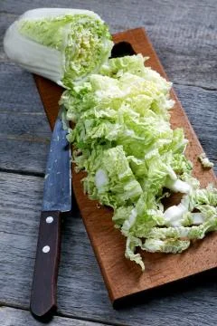 Sliced cabbage and knife on a rustic table Stock Photos