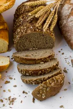 Sliced of cereal bread on white background with wheat ears Foto stock