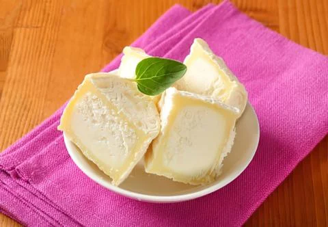Sliced cheese with mint leaf on plate Stock Photos