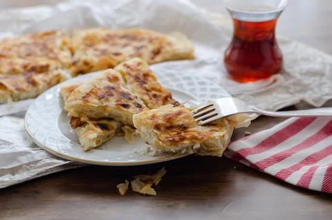 Sliced cheese pastry on the table, next to the turkish tea.(shallow depth of  Stock Photos