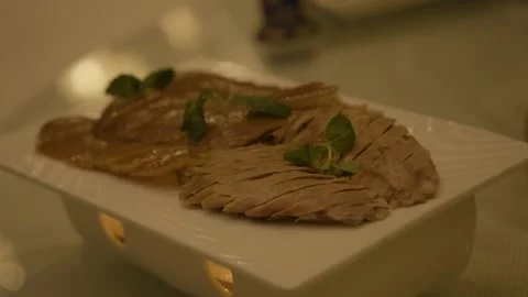Sliced Cooked Meat with Herb Garnish Served on Plate in Beijing Restaurant Stock Footage 345783484