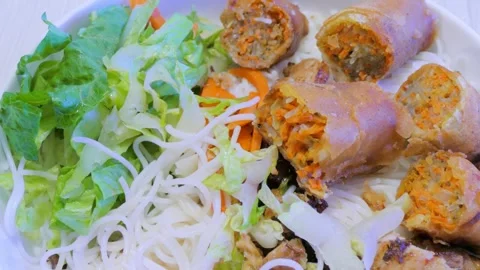 Sliced crispy fried Vietnamese egg roll over rice vermicelli noodle Stock Footage 335852880