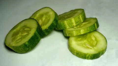 Sliced cucumber on white background. preparing salad with cucumber. Stock Photos