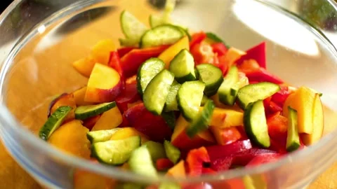 Sliced cucumbers added to red peppers and peaches salad Video stock 333831451