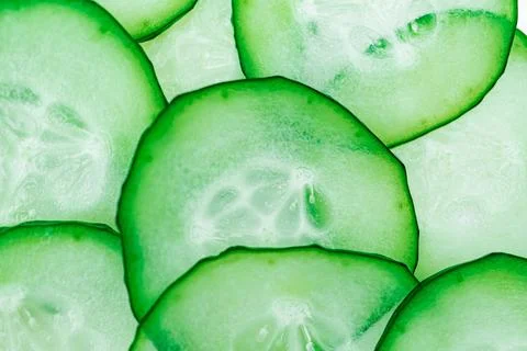 Sliced cucumbers arranged in overlapping pattern, vibrant green slices, cri.. Stock Photos