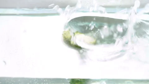 Sliced cucumbers fall into the water Stock Footage 100269691