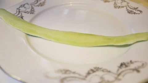 Sliced cucumbers falling down on plate. Cucumbers sliced long pieces. Video stock 125208711