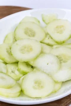 Sliced cucumbers on the plate, macro close up flat lay. Stock Photos