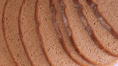 Sliced dark bread rotates on a plate close-up Stock Footage 146722185