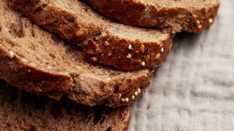 Sliced dark German bread with seeds on fabric background. Stock Footage 333622001